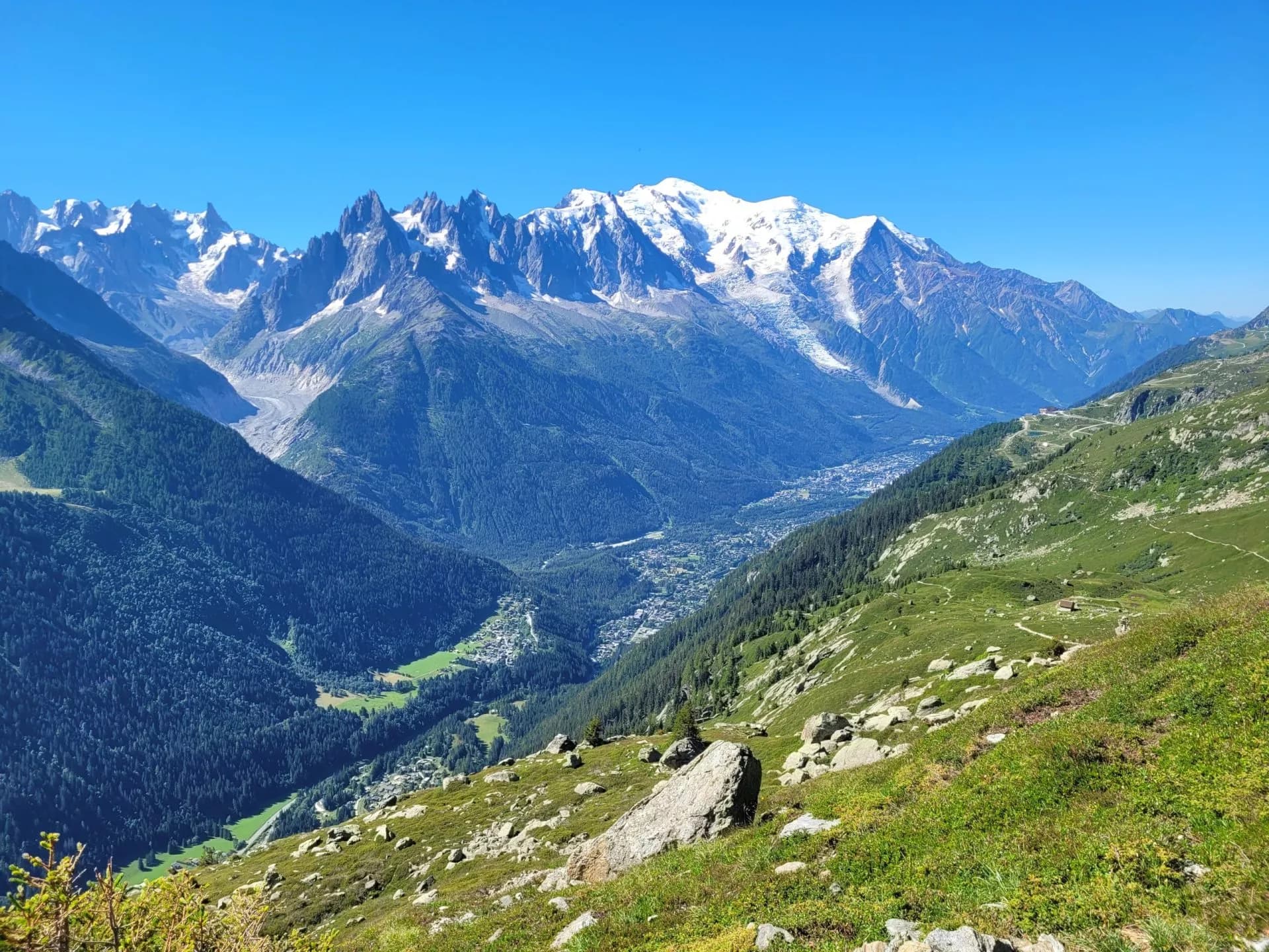 View of Chamonix from below Lac Blanc showing snow-capped mountains and valley town.