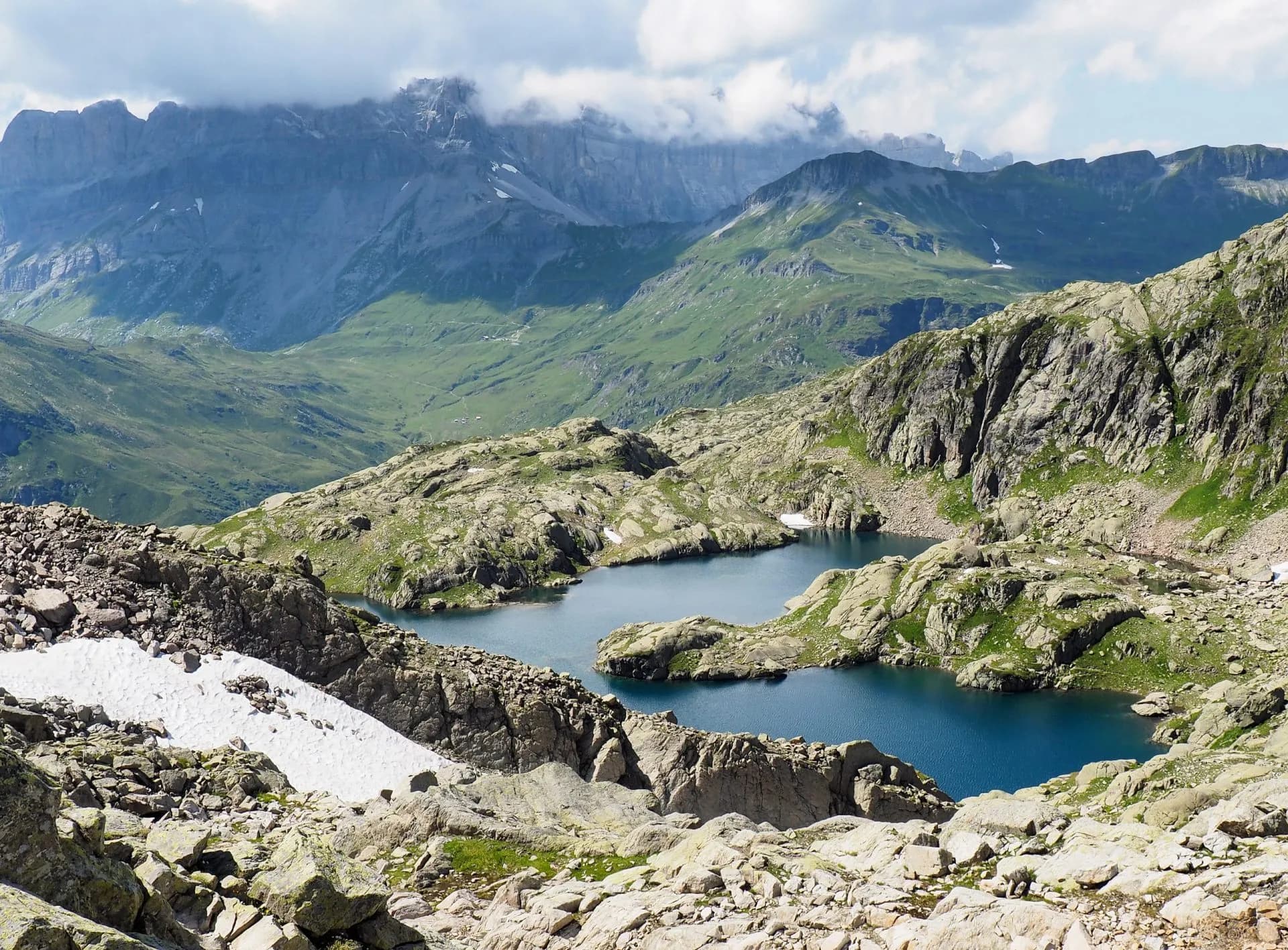 Alpine lakes above Chamonix with rocky terrain and distant green mountains under clouds.