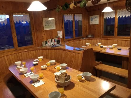 Wooden dining room with built-in seating set for breakfast near Refuge de Lac Blanc.