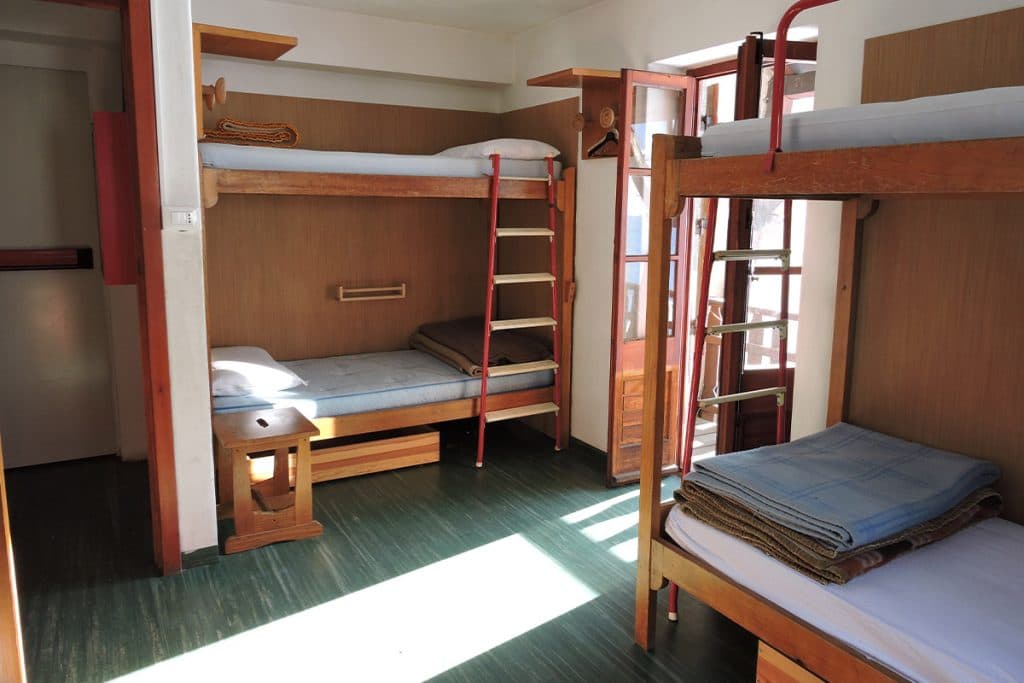 Bunk beds with wooden frames and ladders inside a Rifugio Chapy Mont Blanc dormitory room.