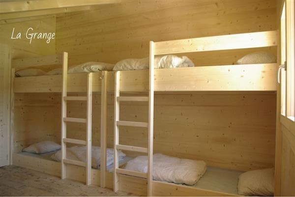 Wooden bunk beds with white bedding inside a room labeled "La Grange