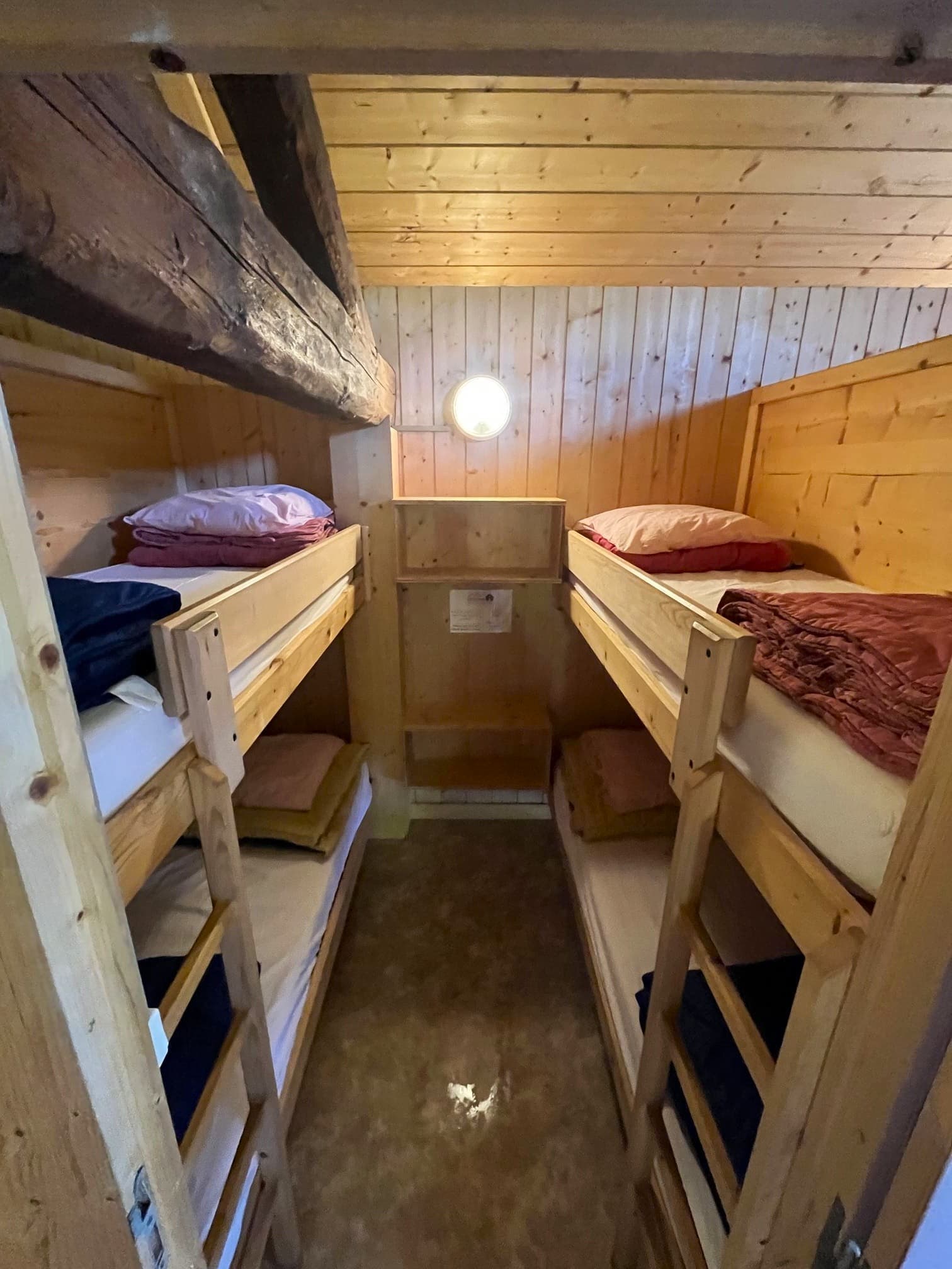 Bunk beds in a small, wood-paneled room with exposed ceiling beams, Les Écuries de Charamillon.