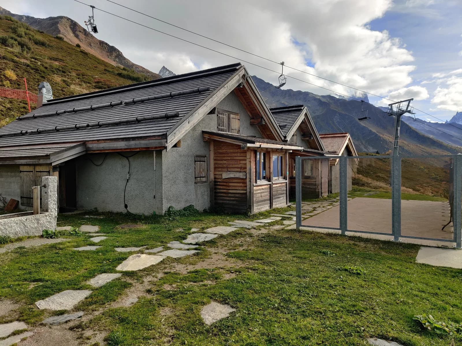 Mountain refuge with ski lift and stone path at Les Écuries de Charamillon