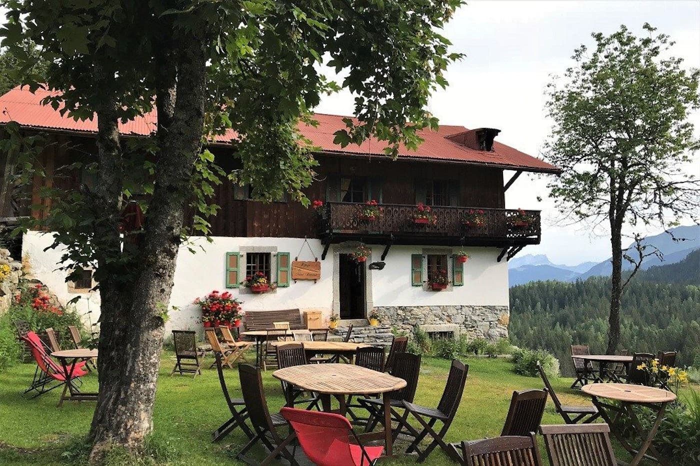 Refuge de Nant Borrant with outdoor seating and mountain view in summer.