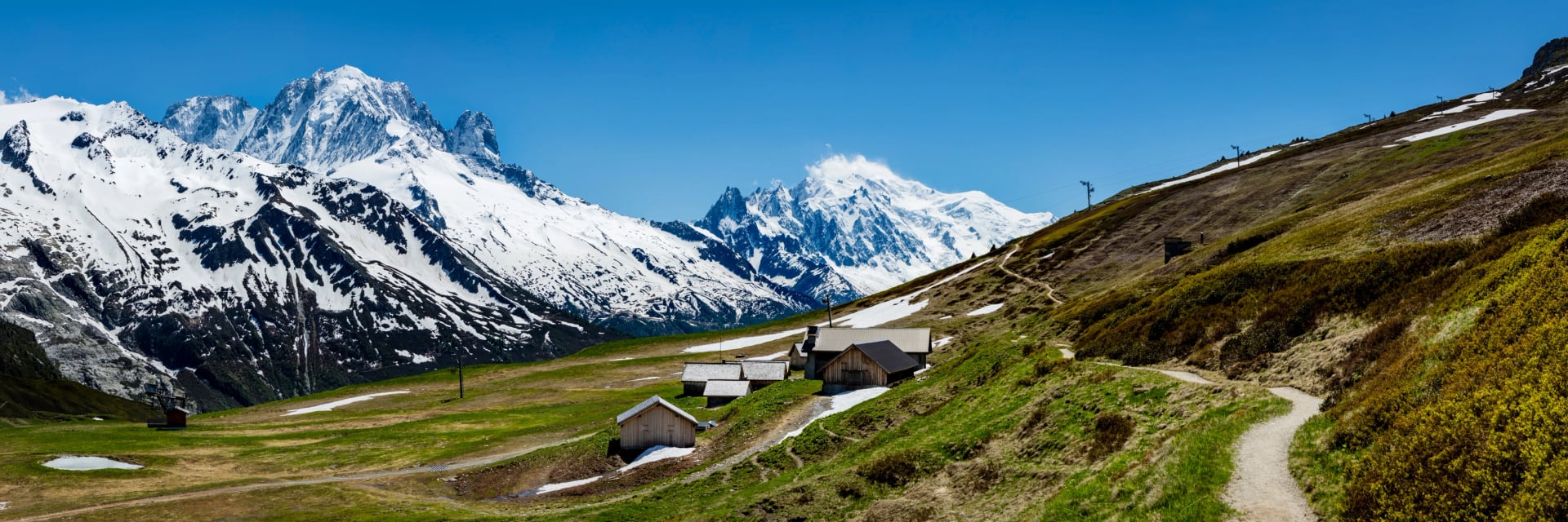 the mont blanc massif and the aguille du midi in the french alpine valley of chamonix showing clear blue skies and snow capped peaks during spring