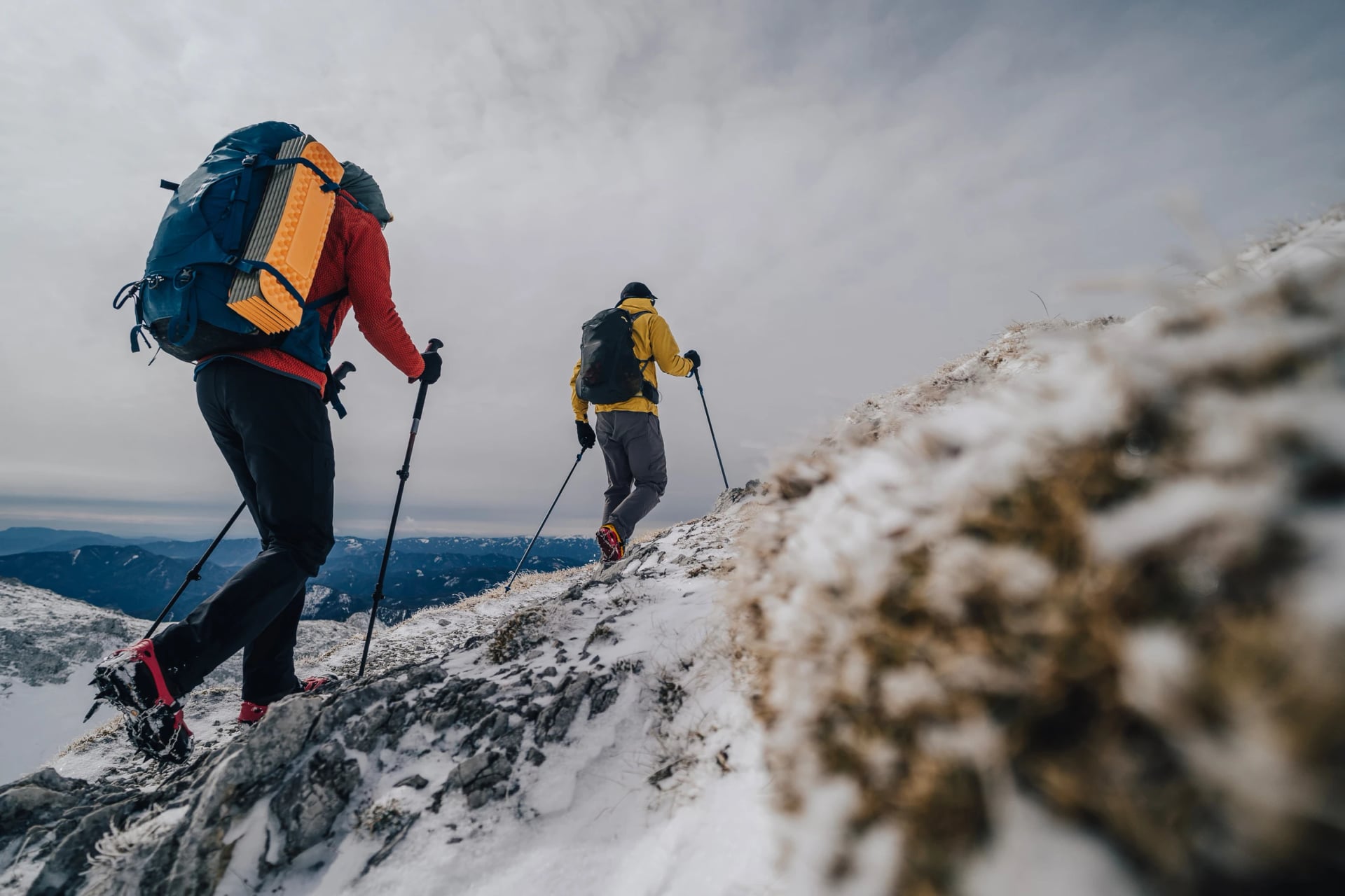 Hiking and trekking in winter mountains. Adventure on a hiking trail, using backpack and trekking poles. Active lifestyle, outdoor sports.