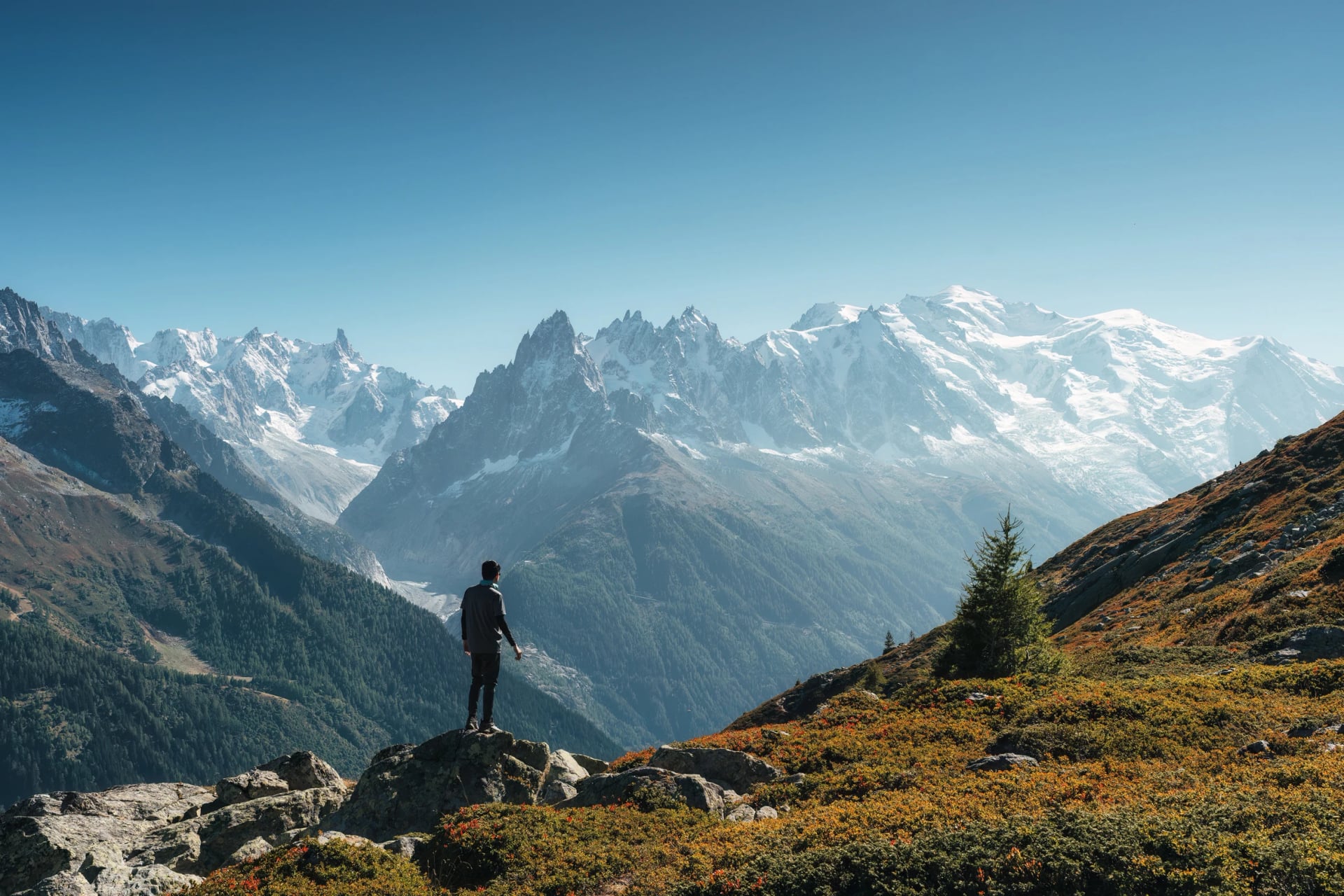 Manlig resenär som står och njuter av Mont Blanc-massivet under vandringen bland de franska Alperna i Chamonix, Frankrike